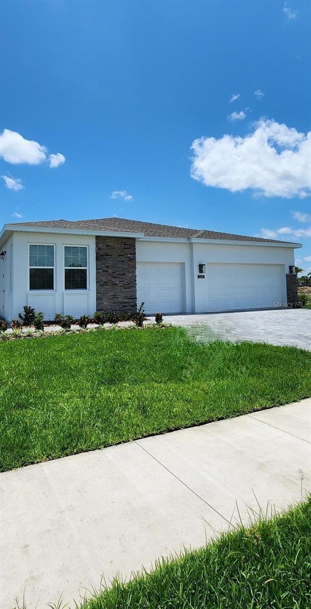 4110 Gooseberry Trl, Kissimmee, FL 34746 - ranch-style house with a front yard, stone siding, stucco siding, and a detached garage