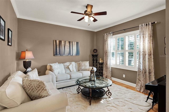 living room with ornamental molding, ceiling fan, and light wood-type flooring