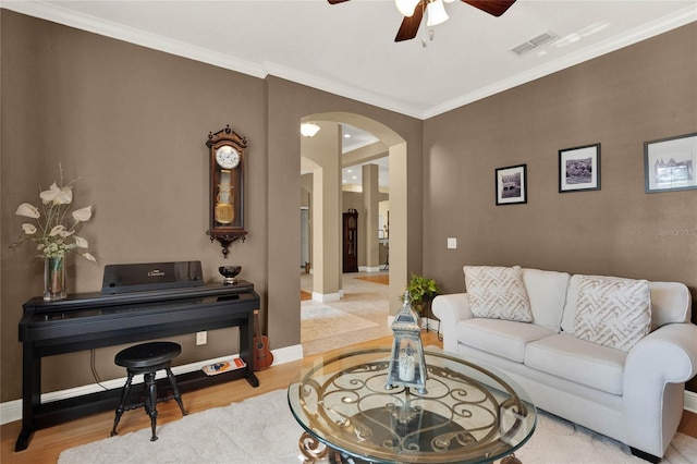 living room featuring crown molding, light hardwood / wood-style floors, and ceiling fan