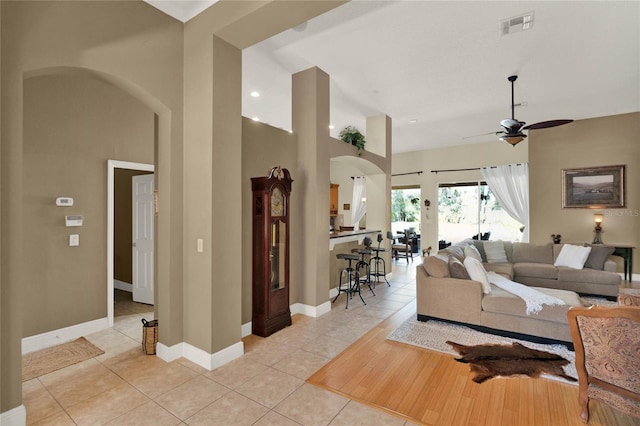 tiled living room featuring a high ceiling and ceiling fan