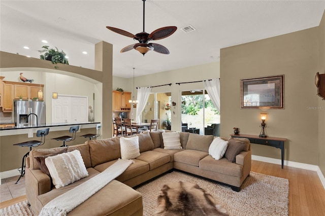 living room featuring ceiling fan and light wood-type flooring