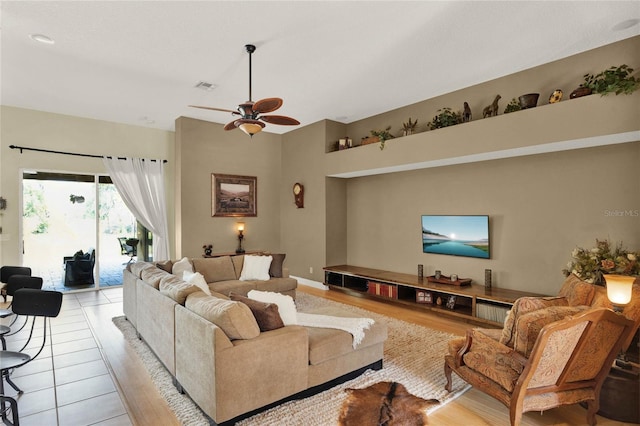 tiled living room featuring ceiling fan