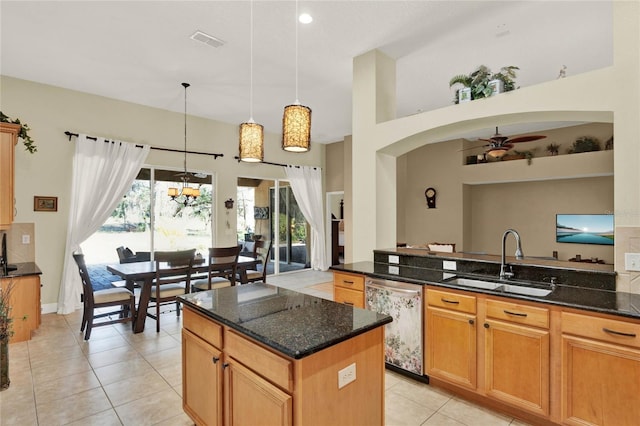 kitchen with a kitchen island, pendant lighting, sink, dark stone countertops, and stainless steel dishwasher