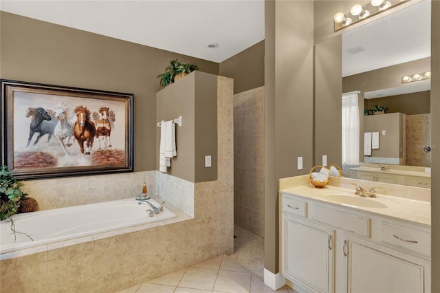 bathroom featuring vanity, tiled bath, and tile patterned flooring