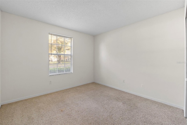 carpeted empty room with a textured ceiling