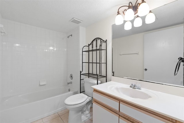 full bathroom featuring tile patterned flooring, vanity, tiled shower / bath combo, toilet, and a textured ceiling