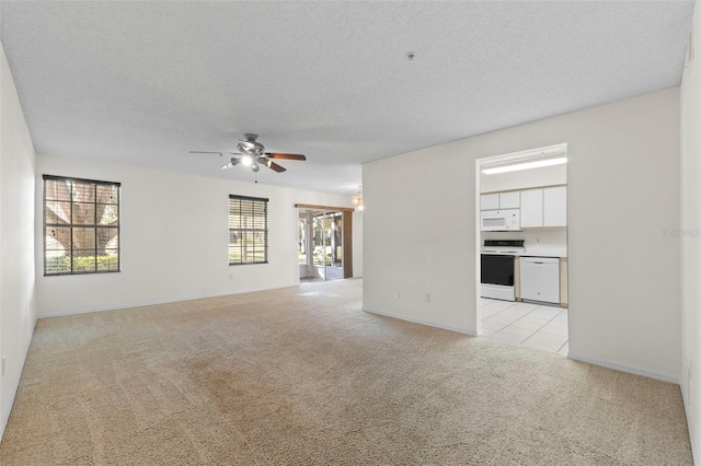 unfurnished living room featuring ceiling fan, light colored carpet, and a textured ceiling