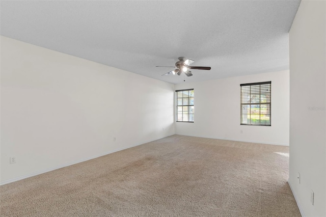 unfurnished room featuring ceiling fan, light colored carpet, and a textured ceiling