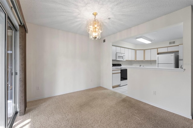 kitchen featuring decorative light fixtures, white cabinets, light colored carpet, white appliances, and a textured ceiling