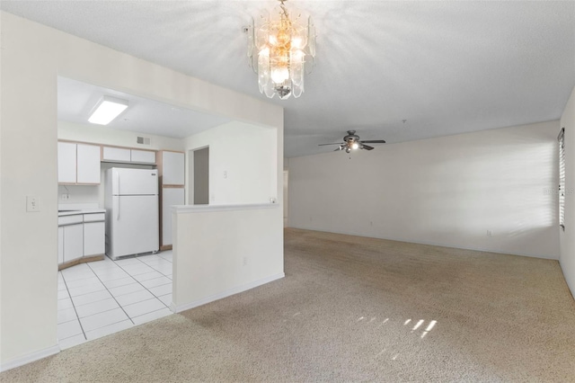 unfurnished living room featuring light carpet, ceiling fan, and a textured ceiling