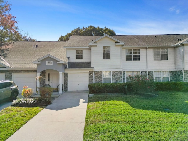 multi unit property featuring a garage and a front yard