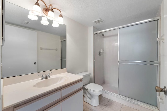 bathroom with vanity, a textured ceiling, a shower with shower door, tile patterned floors, and toilet