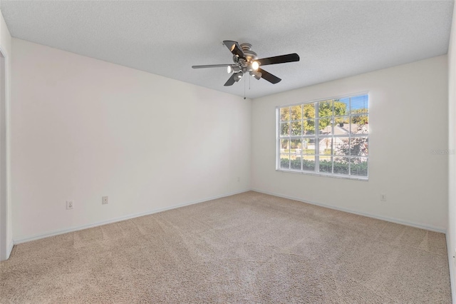 unfurnished room featuring ceiling fan, light colored carpet, and a textured ceiling