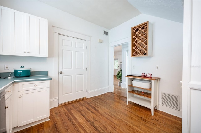 kitchen featuring white cabinetry, vaulted ceiling, and dark hardwood / wood-style floors