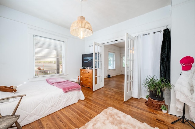 bedroom with wood-type flooring and french doors