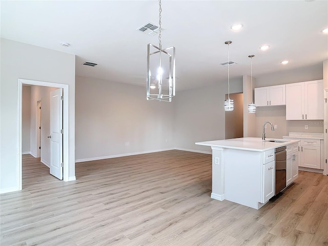 kitchen featuring sink, white cabinetry, hanging light fixtures, stainless steel dishwasher, and a kitchen island with sink