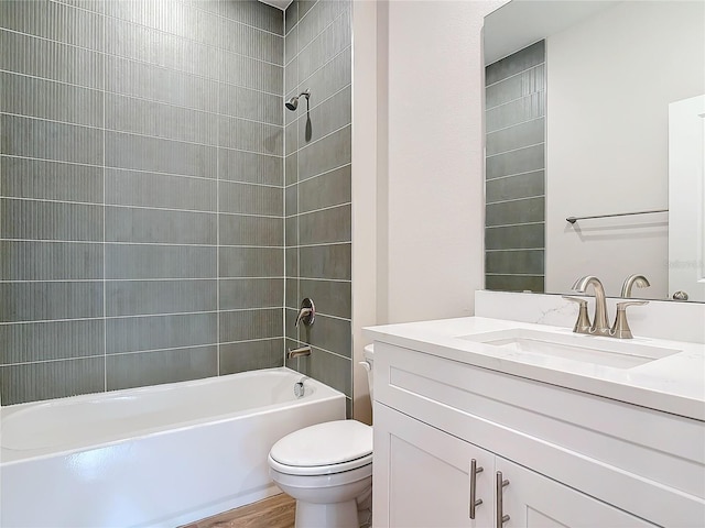 full bathroom with vanity, toilet, and tiled shower / bath combo