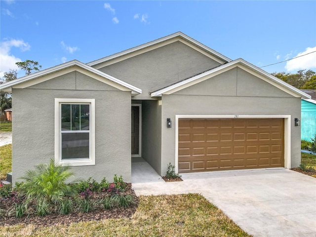 ranch-style home with driveway, an attached garage, and stucco siding