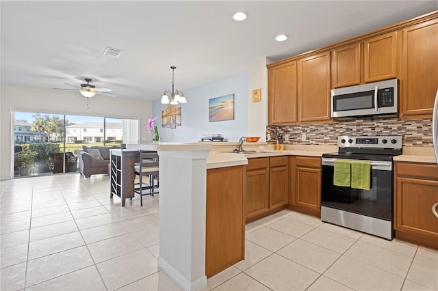 kitchen featuring backsplash, light tile patterned floors, stainless steel appliances, and sink