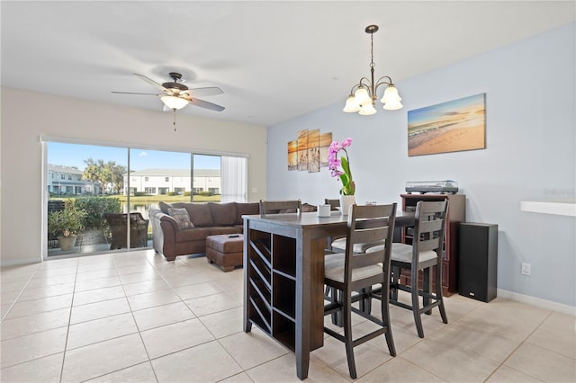 dining area with light tile patterned floors and ceiling fan with notable chandelier