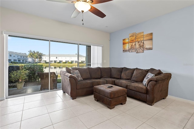 living room featuring light tile patterned flooring, ceiling fan, and a water view