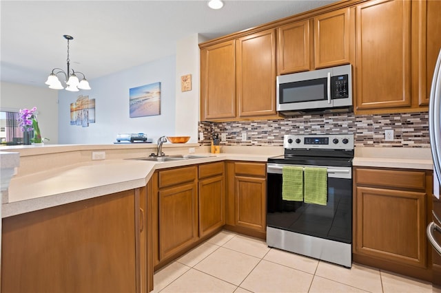 kitchen featuring sink, light tile patterned floors, appliances with stainless steel finishes, decorative backsplash, and decorative light fixtures