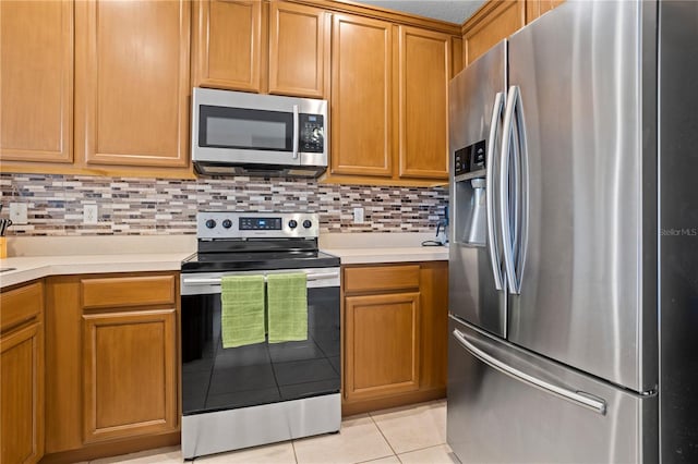 kitchen featuring tasteful backsplash, stainless steel appliances, and light tile patterned flooring