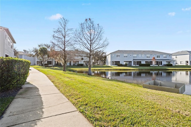 exterior space featuring a lawn and a water view