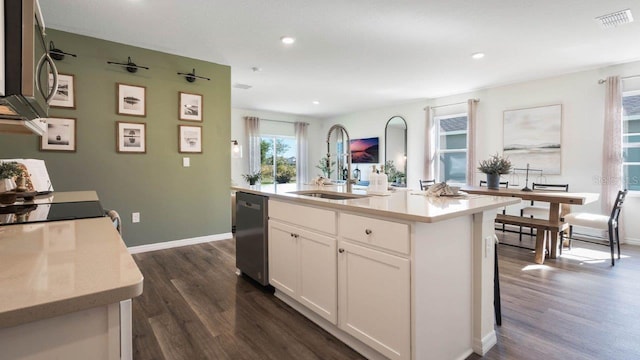 kitchen featuring sink, a center island with sink, dark hardwood / wood-style floors, stainless steel appliances, and white cabinets