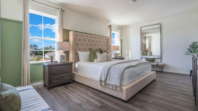 bedroom with dark hardwood / wood-style flooring and multiple windows