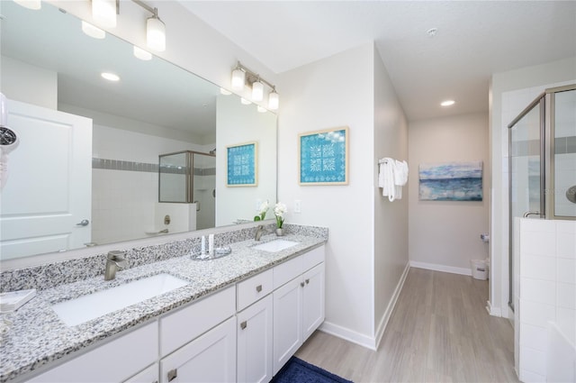 bathroom featuring a shower with door, vanity, and hardwood / wood-style floors