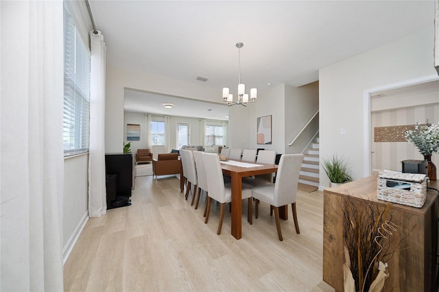 dining area featuring an inviting chandelier and light wood-type flooring