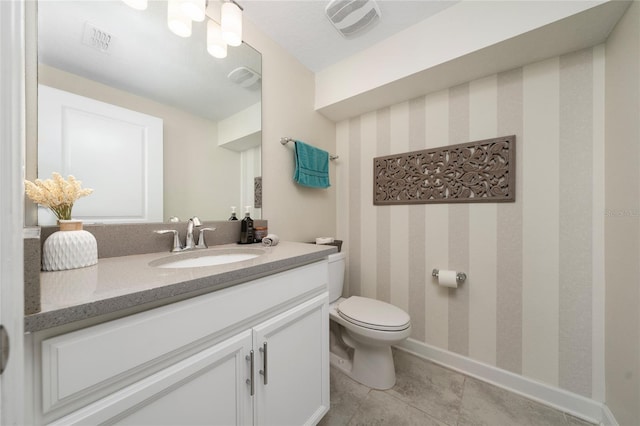 bathroom with vanity, tile patterned flooring, and toilet