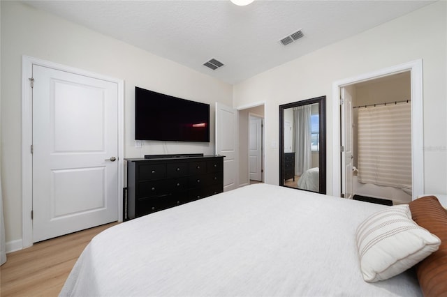 bedroom featuring light hardwood / wood-style flooring and a textured ceiling