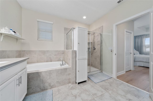 bathroom featuring vanity and independent shower and bath