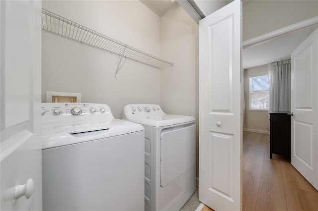 laundry room with light hardwood / wood-style floors and washing machine and dryer