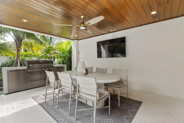 view of patio / terrace featuring ceiling fan, an outdoor bar, and exterior kitchen