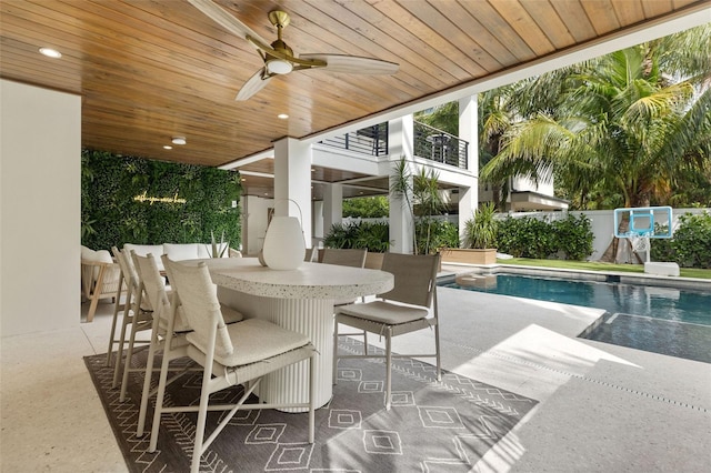 view of pool with an outdoor bar, ceiling fan, and a patio area