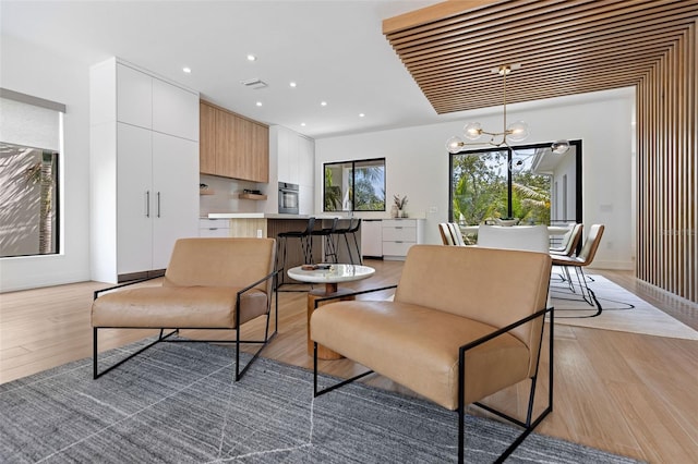 living area featuring an inviting chandelier and light hardwood / wood-style flooring