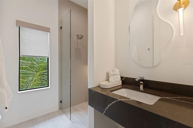 bathroom featuring a tile shower and vanity