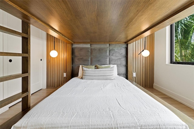 bedroom featuring light hardwood / wood-style floors, wooden walls, and wooden ceiling