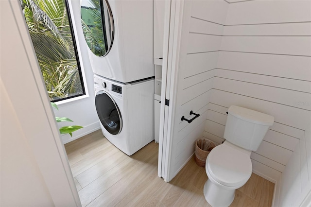 laundry area featuring light hardwood / wood-style floors and stacked washer and clothes dryer