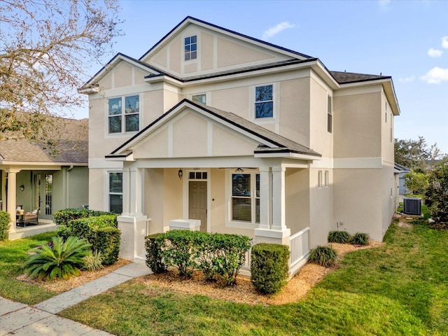 view of front of property with covered porch, central air condition unit, and a front lawn