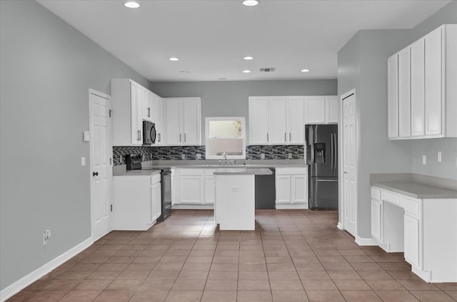 kitchen featuring tasteful backsplash, white cabinets, a center island, and black appliances