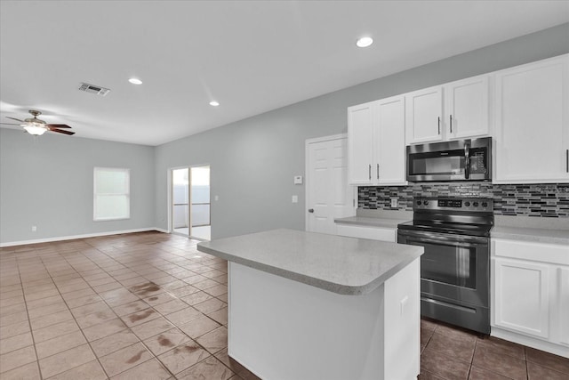 kitchen featuring tasteful backsplash, appliances with stainless steel finishes, a kitchen island, and white cabinets