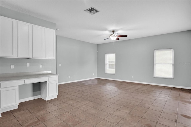 interior space featuring ceiling fan and built in desk