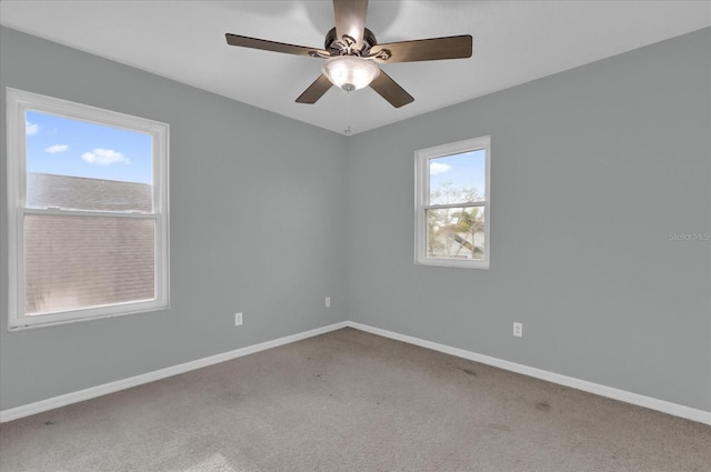 carpeted spare room with ceiling fan