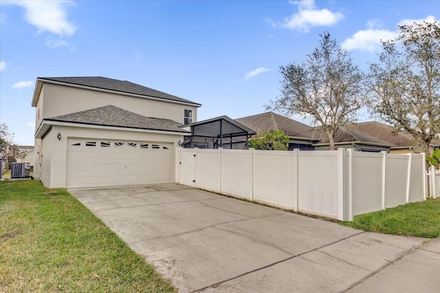 view of property exterior featuring a garage, central air condition unit, and a lawn