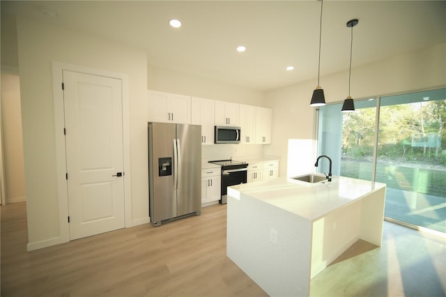 kitchen with pendant lighting, sink, white cabinetry, a kitchen island with sink, and stainless steel appliances