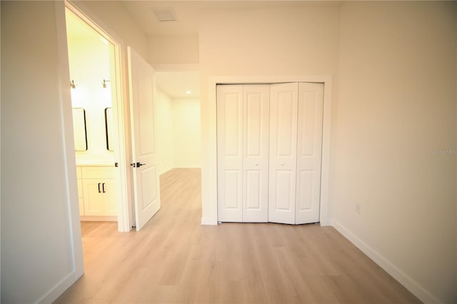 unfurnished bedroom with a closet and light wood-type flooring